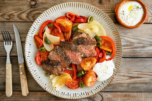 Rindersteak mit Joghurtdip auf warmem Tomaten-Paprika-Salat