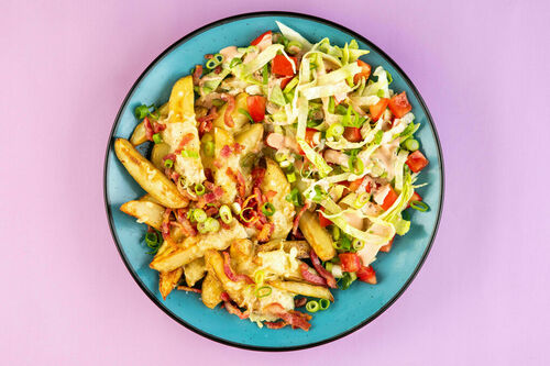 Cheddar-Kartoffelwedges mit Speck serviert mit frischem Salat