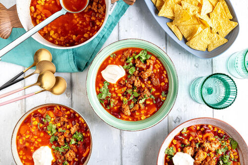 Chili sin Carne mit Veggie-Hack serviert mit Crème fraîche und Tortillachips