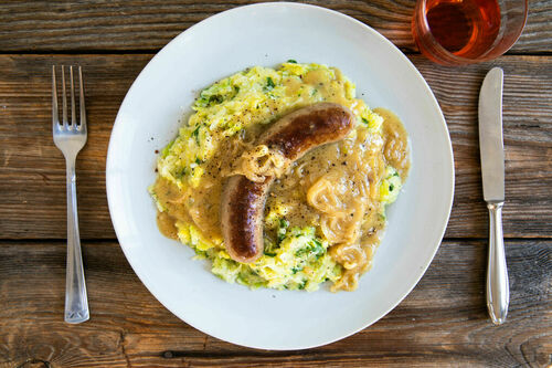 Herzhafte Rindswurst mit Zwiebelsauce auf Kartoffel-Wirsing-Stampf