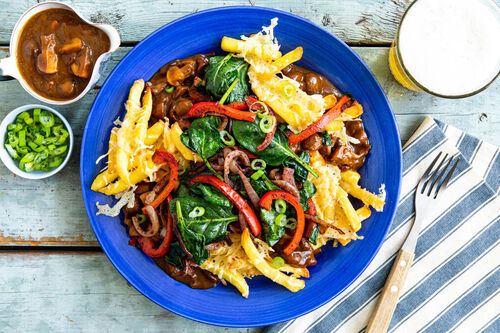 Poutine mit würzigem Gemüse und Käse und aromatischer Champignonsauce