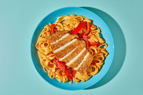 Krosses Hähnchenschnitzel auf Tagliatelle mit cremiger Cajun-Gemüse-Sauce