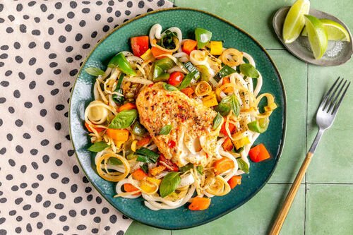 Zartes Kabeljaufilet auf Udon-Nudeln mit Gemüse und Basilikum