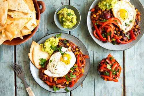 Huevos Rancheros mit Bohnen und Mais dazu Guacamole und Tortillachips