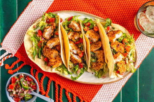 Tacos with fried onion and panko breaded fish topped with pico de gallo