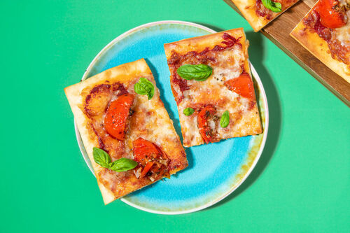 Pizza mit aromatischem Tomatenconfit klassisch mit Mozzarella und Basilikum