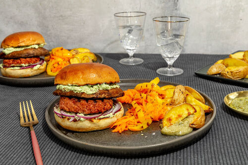 Veggie-Burger mit Feta-Basilikum-Creme dazu gebackene Kartoffelwedges