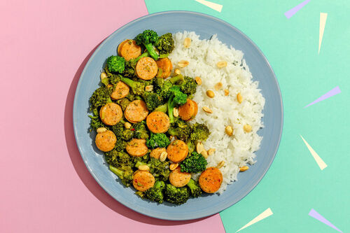 Gebratene Geflügelwurst mit Brokkoli auf Jasminreis, garniert mit Erdnüssen