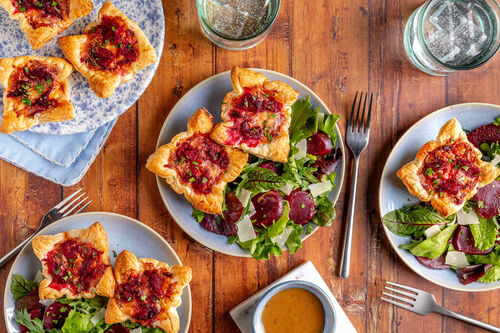 Mini-Quiches mit Ziegenkäse und Roter Bete serviert an Wildkräutersalat