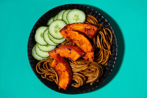 Scharfer Kürbis auf Udon-Nudeln mit Erdnusssauce und Thai-Basilikum