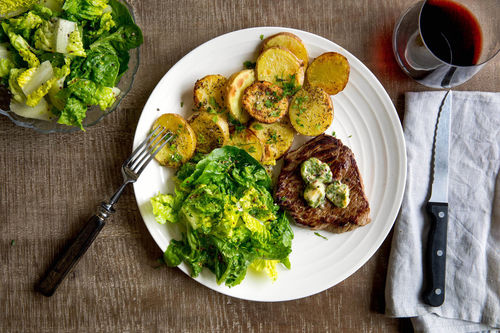 Veggie-Steak mit Röstkartoffeln und Petersilien-Senf-Butter, dazu Salat