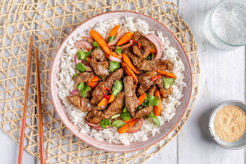 Rindersteakstreifen auf Jasminreis mit Gemüse und Koriander