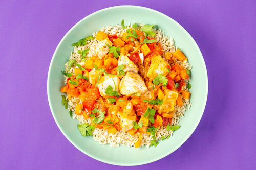 Gemüsepfanne mit Alaska-Seelachs und Koriander an braunem Reis