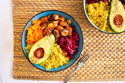 Rainbow Bowl mit gebackenem Tofu und Avocado auf Kurkuma-Quinoa