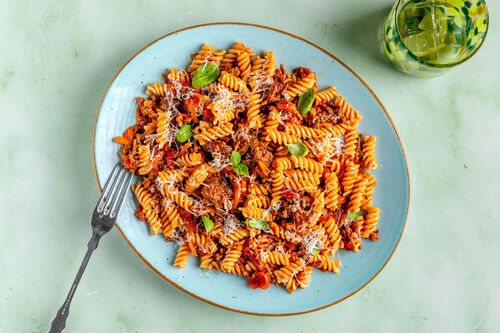 Vollkornfusilli mit Sauce bolognese mit Karotten und frischem Basilikum