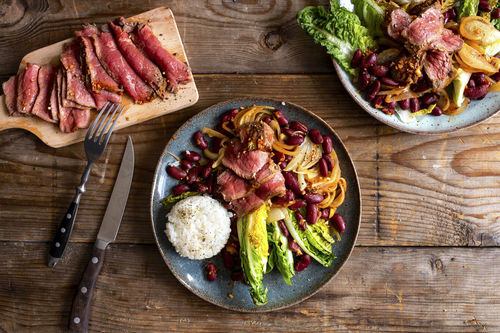 Koreanisches Rindersteak an Bohnen, Reis und gebratenem Salat