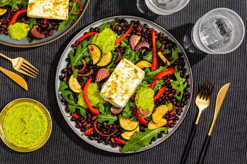 Gegrillter Feta mit Guacamole auf buntem Rucola-Gemüse mit Bohnen