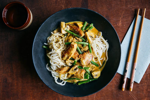 Thailändisches Huhn mit Woknudeln in gelber Currysauce