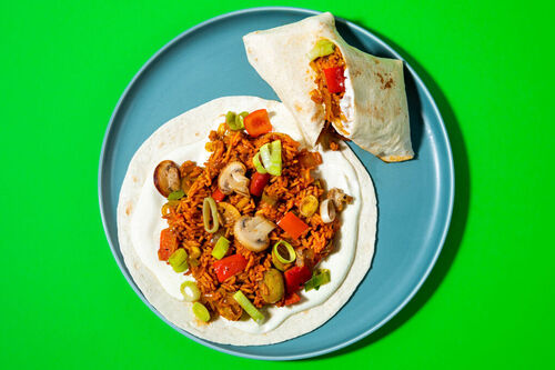 Cajun-Gemüseburrito mit Fetasauce gefüllt mit würzigem Tomatenreis
