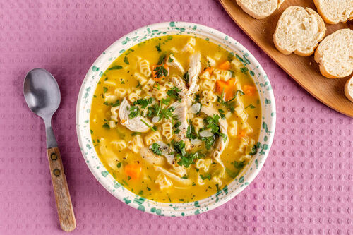 Hühnersuppe mit Bio-„Bauernhof“-Pasta mit Gemüse und Käse, dazu Baguettescheiben