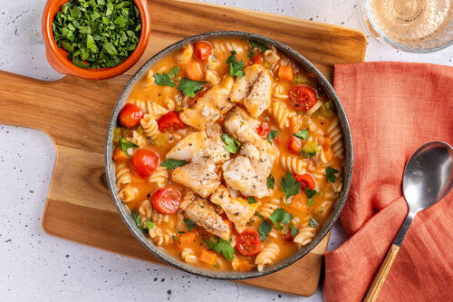 Fisch-Chowder mit Vollkornpasta italienische Art mit Tomaten und Petersilie