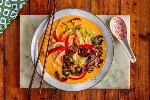Scharfe Kokosmilch-Nudelsuppe mit Paprika und gebratenen Champignons