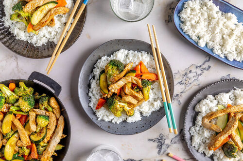 Asia-Schweineschnetzel mit Gemüse serviert auf Jasminreis