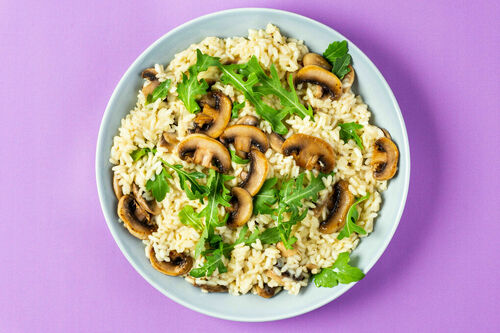 Veganes Pilzrisotto mit Hefeflocken verfeinert mit pfeffrigem Rucola