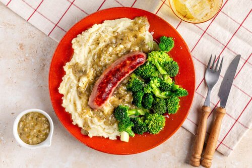 Saftige Bio-Rindswurst mit Kartoffelpüree mit Brokkoli und Basilikum-Kapern-Sauce