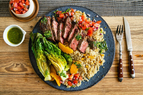 Rindersteak und gebratener Salat auf Orangen-Quinoa mit Tomatensalsa