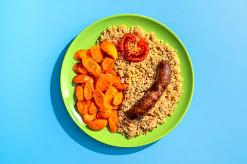 Deftige Rindswurst mit Ofenkarotten auf würzigem Tomatencouscous