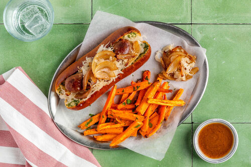 Hotdog mit Bio-Rindswurst mit Sauerkraut und Gemüsepommes