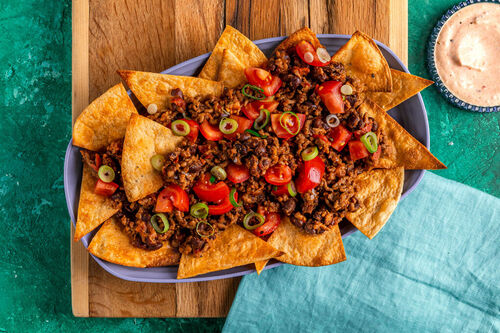Loaded Nachos mit Chili vom Bio-Rind garniert mit Lauchzwiebeln und Tomaten