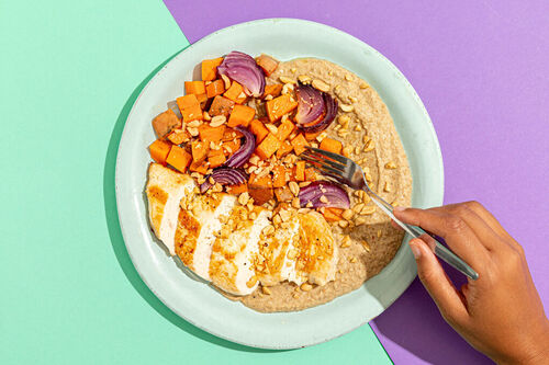 Ofenhähnchen auf Linsenhummus dazu geröstete Süßkartoffeln und Erdnüsse