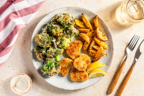 Goldene Fischnuggets an Brokkoligratin dazu Kartoffelspalten aus dem Ofen