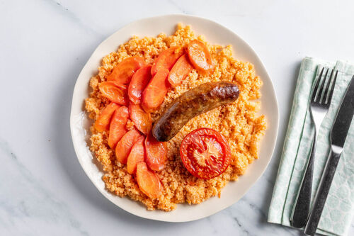 Deftige Rindswurst mit Ofenkarotten auf würzigem Tomatencouscous