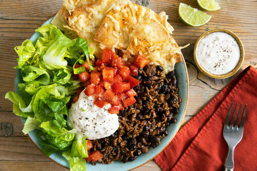Burrito Bowl mit Bio-Rind und Bohnen mit Salsa und Tortillachips mit Käse