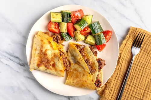 Tortillataschen mit Rinderhack und Cheddar dazu würziger Tomaten-Gurken-Salat