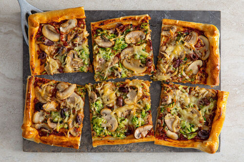 Knusprige Gemüsepizza mit Oliven überbacken mit jungem Gouda