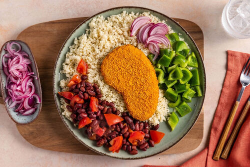 Veggieschnitzel mit schwarzen Bohnen dazu Couscous und grüne Paprika