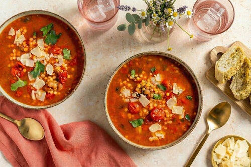 Italienische Minestrone mit Kirschtomaten serviert mit Käse und Knoblauchbrot