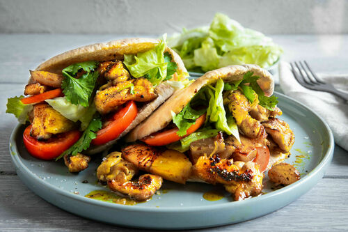 Curry-BBQ-Hähnchen mit Ananas im Pitasandwich mit Tomate und Salat