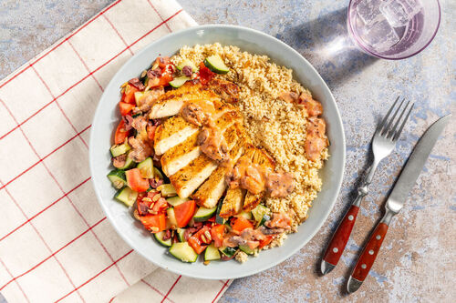 Schweinesteak in Tomaten-Oliven-Sauce auf würzigem Couscous, dazu Gurkensalat