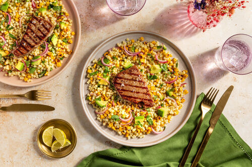 Thunfischsteak mit eingelegten Zwiebeln auf Perlencouscous-Salat mit Avocado und Mais