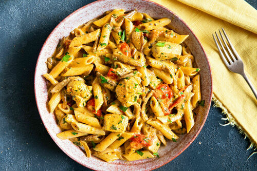 Pasta mit Hähnchen und Austernpilzen in cremiger Currysauce mit Tomaten