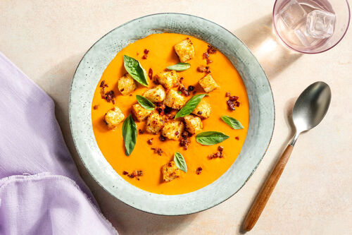 Cremige Tomatensuppe mit Bacon-Croûtons und frischem Basilikum