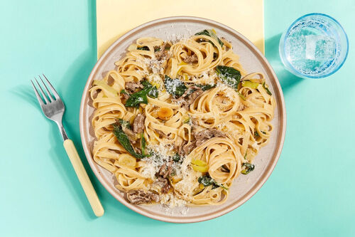 Cremige Pasta in weißer Veggie-Bolognese mit zartem Lauch und Spinat