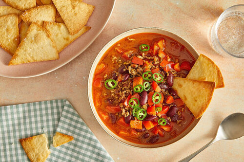 Würziges Chili con Carne mit Hackfleisch serviert mit Jalapeño-Topping & Tortillachips