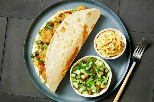 Falafel-Wraps mit buntem Salat und Hummus mit Harissa