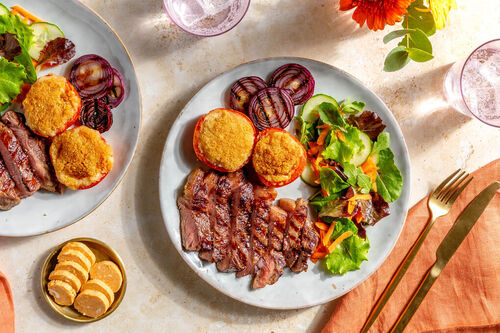 Steak mit BBQ-Butter und Röstzwiebeln dazu Tomaten mit Bröselhaube und Salat
